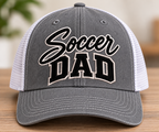 Soccer Dad embroidered trucker hat mockup in heather gray and white with black lettering and light outlines